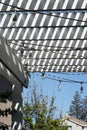 Vertical closeup shot of a white wooden striped canopy over a yard on a sunny day