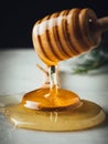 Vertical closeup shot of a wood dipper of honey and honey itself leaking from it