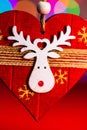 Vertical closeup shot of a wooden handmade decoration with a reindeer against the bokeh lights