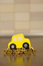 Vertical closeup shot of a wooden yellow toy car on golden screws on a wooden surface Royalty Free Stock Photo