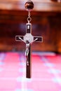 Vertical closeup of a small cross against blurred background