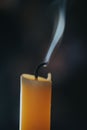 Vertical closeup of a smoking candle on a blurry background