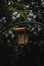 Vertical closeup of a street lantern decorated with metallic flowers Royalty Free Stock Photo