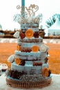 Vertical closeup of a 4-tier wedding cake decorated with fresh fruits and white roses Royalty Free Stock Photo