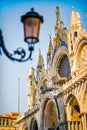 Vertical closeup of top part of facade of Basilica and Cathedral of San Marco in Venice, Italy, with vintage lamp. Travel tourism Royalty Free Stock Photo