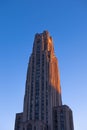 Vertical closeup of the University of Pittsburgh during sunset on a blue sky background