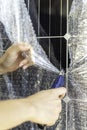 Vertical closeup view of faceless hands cutting a bubble wrapping from the monocrystalline solar panel Royalty Free Stock Photo