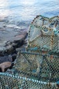 Vertical closeup of weathered prawn traps piled on a dock in western Scotland