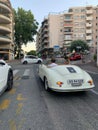 Vertical closeup of a white Porsche Nice Cote D Azur standing on the yard