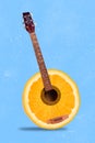 Vertical collage illustration of creative half orange acoustic guitar isolated on blue painted background Royalty Free Stock Photo