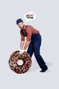 Vertical collage portrait of cheerful auto car mechanic man big chocolate donut instead tire wheel peat stop isolated on