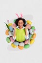 Vertical composite art collage of young cute excited girl wear green vest pink bunny ears inside basket easter eggs Royalty Free Stock Photo