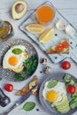 Vertical composition. Delicious and healthy breakfast. Fried eggs, toast with avocado and tomatoes, juice, lemon and Royalty Free Stock Photo