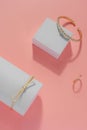 Vertical composition of Modern golden bracelets and ring on pink background Royalty Free Stock Photo