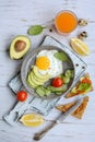 Vertical composition of a plate with scrambled eggs, toast with avocado and tomatoes, juice and lemon slices on a Royalty Free Stock Photo