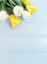 Vertical composition of spring flowers on light blue wooden background. White and yellow tulips. Advertising content for Birthday Royalty Free Stock Photo