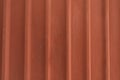 Vertical corrugated fence of matted orange metal sheets. Royalty Free Stock Photo