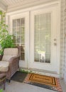 Vertical Cottage pane front door wicker armchairs and stairs viewed at the home entrance Royalty Free Stock Photo