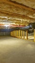 Vertical crop Basement or crawl space with upper floor insulation and wooden support beams Royalty Free Stock Photo