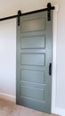 Vertical crop Closed sliding gray panel door with black handle against white wall of home Royalty Free Stock Photo