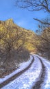 Vertical crop Dirt road trail with tire track and snow in winter in Provo Canyon mountain