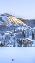 Vertical crop Snowed in mountain in Park City during winter with homes under overcast sky