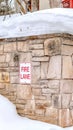 Vertical crop Stone retaining wall with Fire Lane sign on a hill with thick snow in winter Royalty Free Stock Photo