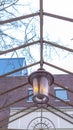 Vertical crop Vintage outdoor lamp hanging on the gable metal roof frame of a pergola