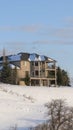 Vertical crop Wasatch Mountains snowy neighborhood with beautiful house against blue sky