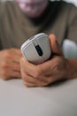 Vertical cropped shot of man holding white ergonomic wireless computer mouse with modern design, focusing on comfortable Royalty Free Stock Photo