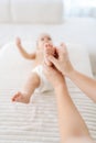 Vertical cropped shot of unrecognizable mother or masseuse massaging foot of infant baby. Little infant receiving feet Royalty Free Stock Photo