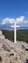 Vertical of a cross on the top of the rock. Royalty Free Stock Photo