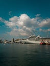 Vertical of a cruise ship on the port of Genova in Italy under the blue sky with fluffy clouds