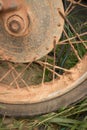 Vertical CU muddy rim and tire of light motorcycle on grass