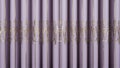 vertical curtain strip fully closed, with little vertical undulation, in light lilac color with golden prints. Royalty Free Stock Photo