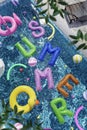 Vertical 3D render collage refreshing crystal clean clear poolside water rubber floating SUMMER letters leisure