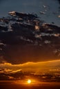 Vertical Dark, heavy clouds push down setting sun Royalty Free Stock Photo