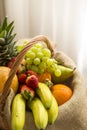 Vertical detail of a basket full of fruits on a light background - high key