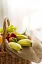 Vertical detail of a basket full of fruits on a light background - high key