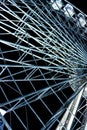 vertical detail of a white illuminated ferris wheel at night in a amusement park