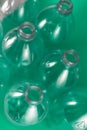 Vertical diagonal view of a pack of empty and recyclable water bottles, with no caps, on a colored vibrant sea green