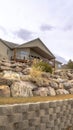 Vertical Dirt road along homes on a slope with huge rocks and concrete retaining wall Royalty Free Stock Photo