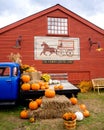 Vertical display of pumpkins, flowers, gourds and straw on a classic blue American pickup parked Royalty Free Stock Photo