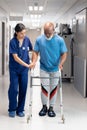 Vertical of diverse female doctor helping senior male patient use walking frame, copy space Royalty Free Stock Photo