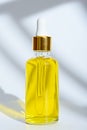 Dropper glass bottle with yellow cosmetic oil on white background Royalty Free Stock Photo