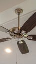 Vertical Electrical fan with built in lights installed on decorative wooden ceiling beam