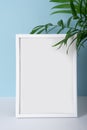 Vertical emply summer white photo frame mockup on blue background with palm leaves for your desing