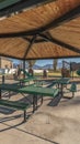 Vertical Empty green tables and benches in an urban park