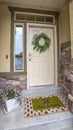 Vertical Entrance of a home with white wooden front door sidelight and transom window