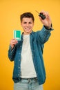 Vertical excited Young Man Holding Car Keys and New Driver L Sign Against a Vibrant Yellow Background. Caucasian guy Royalty Free Stock Photo